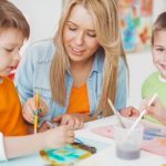 Begeleider met kinderen aan het schilderen